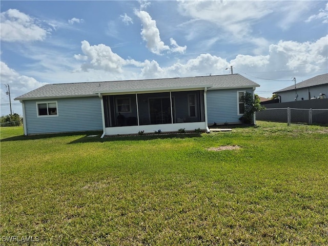 rear view of property with a lawn, fence, and a sunroom