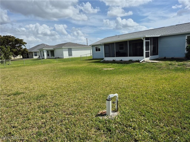 view of yard featuring a sunroom and a fenced backyard