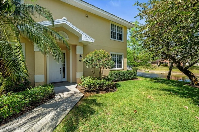 view of front of home featuring stucco siding and a front yard