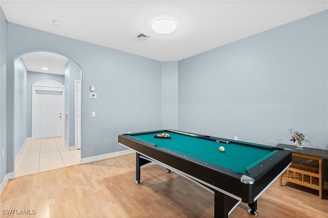 game room with arched walkways, visible vents, light wood-type flooring, and baseboards