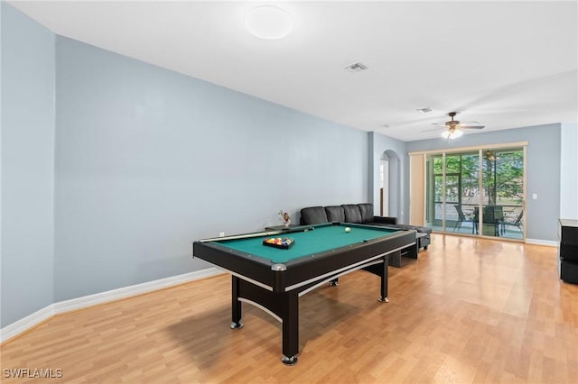 playroom featuring visible vents, light wood-style flooring, a ceiling fan, arched walkways, and baseboards