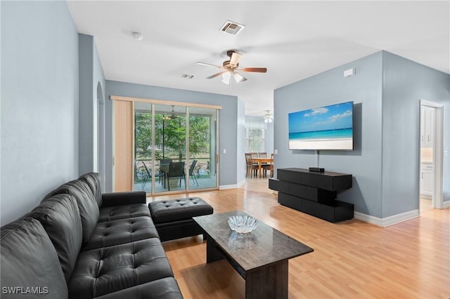 living room with visible vents, plenty of natural light, light wood-type flooring, and baseboards