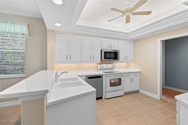 kitchen featuring a sink, appliances with stainless steel finishes, a peninsula, white cabinets, and light countertops