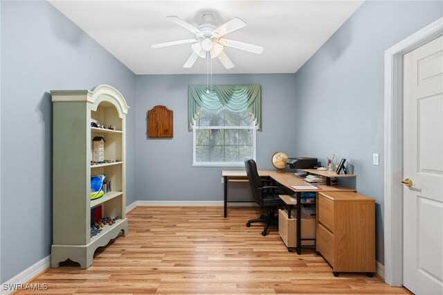 office featuring a ceiling fan, baseboards, and light wood finished floors