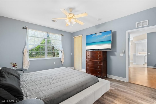 bedroom featuring visible vents, baseboards, and wood finished floors