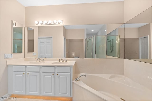 bathroom with a sink, double vanity, a bath, and a shower stall