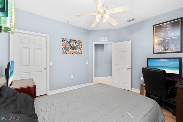 bedroom featuring wood finished floors, visible vents, baseboards, and ceiling fan