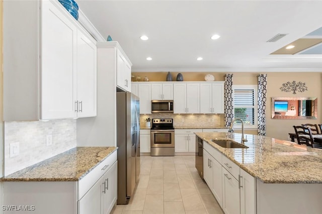 kitchen with visible vents, a kitchen island with sink, a sink, white cabinetry, and stainless steel appliances