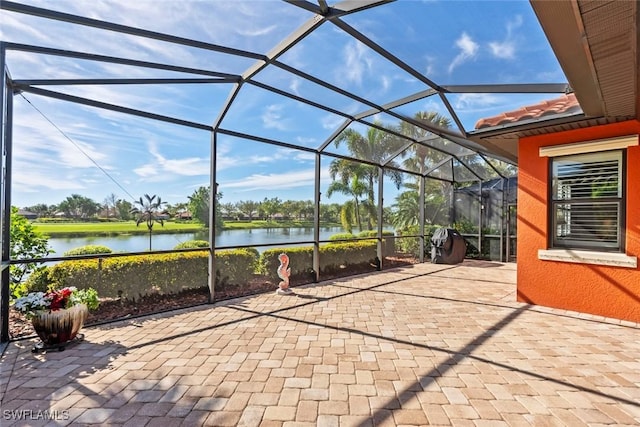 view of patio with a water view and a lanai