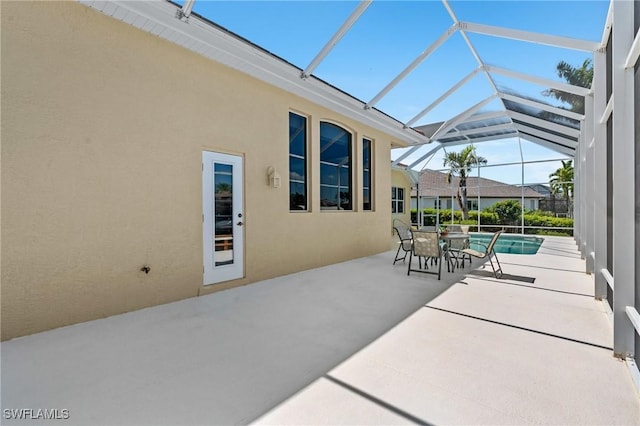 view of patio with glass enclosure and an outdoor pool