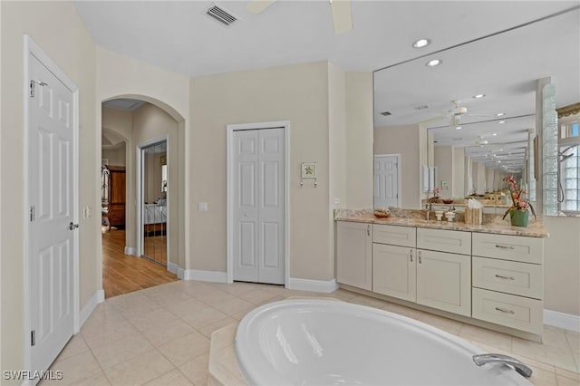 full bath with visible vents, ceiling fan, a bath, a closet, and vanity