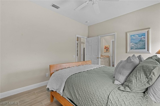 bedroom featuring a ceiling fan, baseboards, visible vents, light wood finished floors, and ensuite bathroom