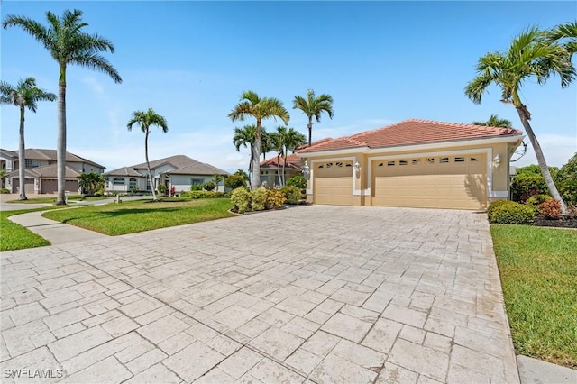 view of front of home featuring an attached garage, stucco siding, a front lawn, a tiled roof, and decorative driveway