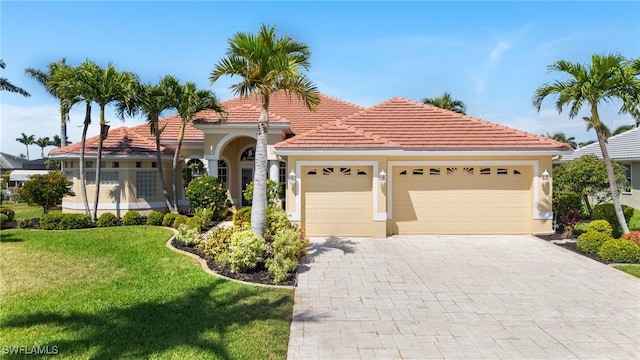 mediterranean / spanish-style house with a tile roof, decorative driveway, a garage, and a front yard