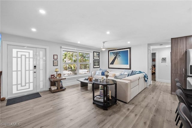 living room featuring light wood-type flooring, ceiling fan, baseboards, and recessed lighting