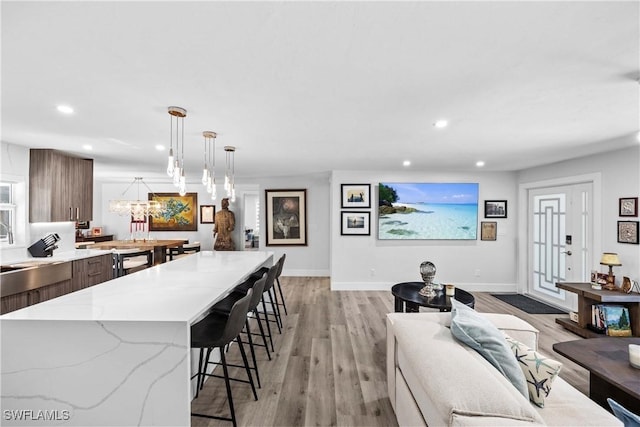 kitchen featuring a spacious island, recessed lighting, light wood-style flooring, and a kitchen bar