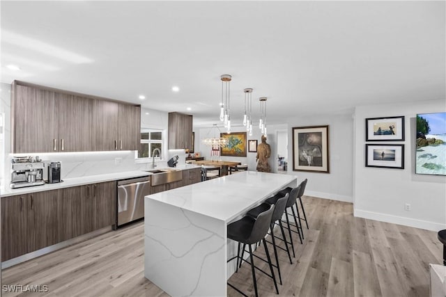 kitchen featuring a kitchen island, dishwasher, a breakfast bar area, and modern cabinets