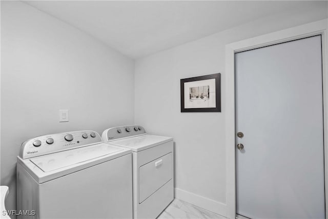 laundry area featuring laundry area, baseboards, marble finish floor, and washer and clothes dryer