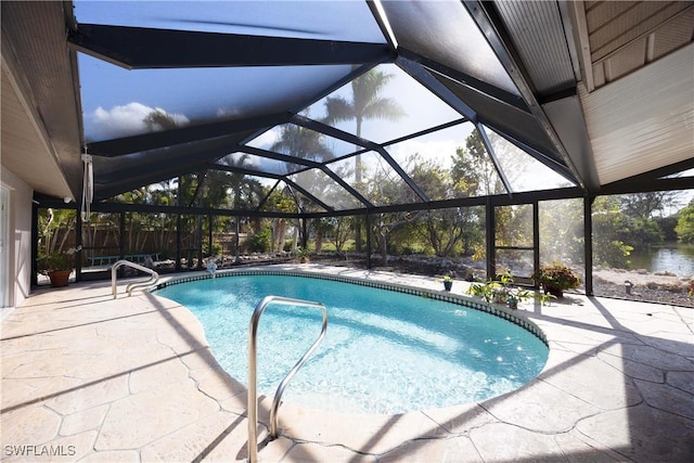 outdoor pool featuring glass enclosure and a patio area