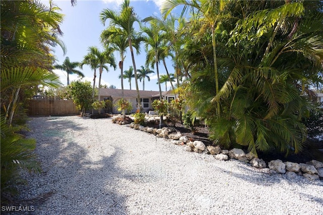 view of yard featuring gravel driveway and fence