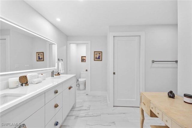 bathroom with marble finish floor, double vanity, recessed lighting, toilet, and a sink