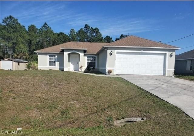 ranch-style house with driveway, a front yard, a garage, and stucco siding