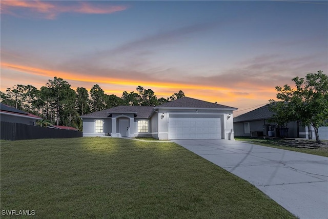 ranch-style home featuring an attached garage, concrete driveway, a front yard, and stucco siding