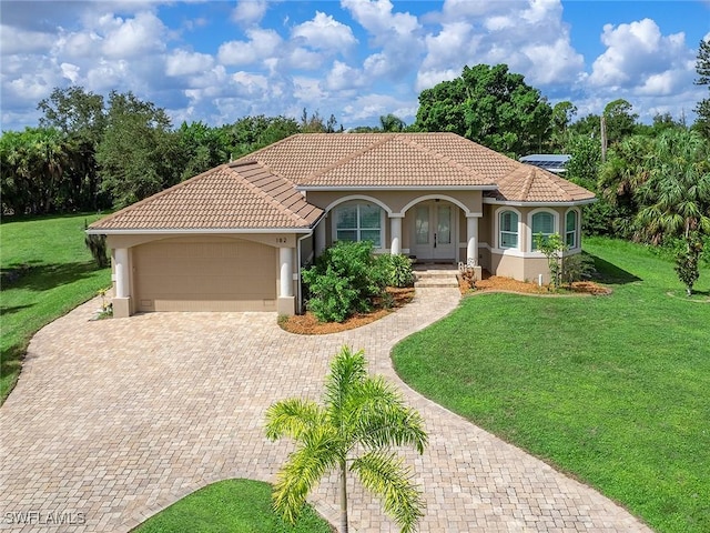 mediterranean / spanish-style house featuring a front yard, a tile roof, an attached garage, and stucco siding