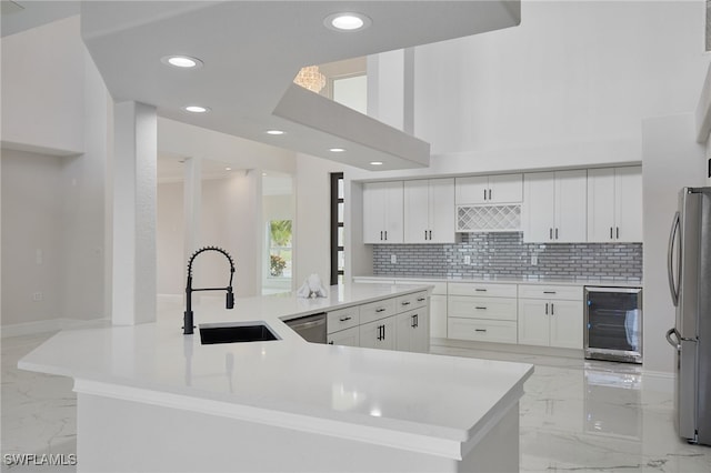 kitchen featuring a sink, decorative backsplash, stainless steel appliances, wine cooler, and marble finish floor