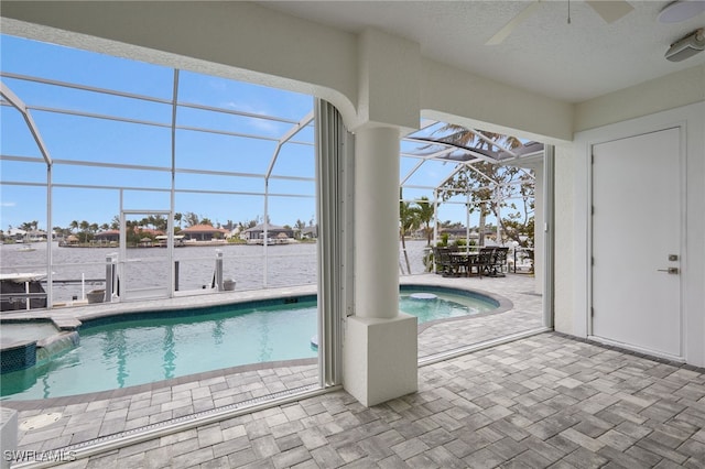 view of swimming pool featuring a pool with connected hot tub, ceiling fan, a lanai, a patio area, and outdoor dining space