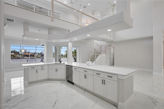 kitchen featuring marble finish floor, a ceiling fan, a sink, stainless steel dishwasher, and open floor plan