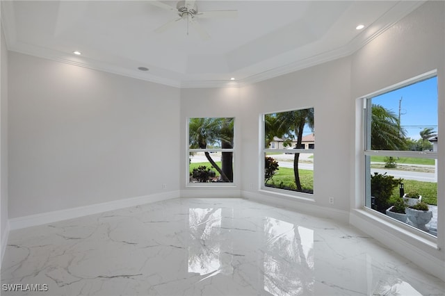 spare room with marble finish floor, a raised ceiling, baseboards, and ornamental molding