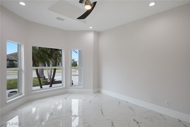 empty room with recessed lighting, marble finish floor, and baseboards