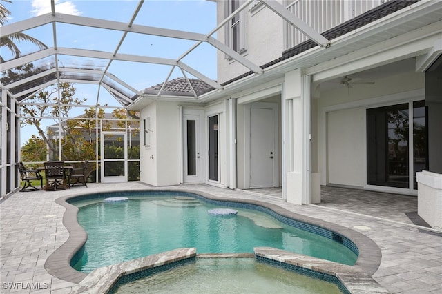 view of pool with outdoor dining area, a pool with connected hot tub, a lanai, and a patio area