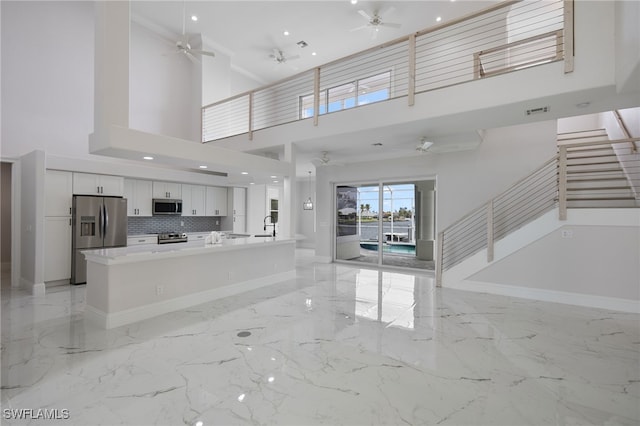 unfurnished living room featuring recessed lighting, baseboards, marble finish floor, and ceiling fan