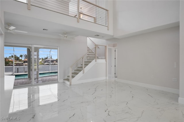 interior space featuring stairway, baseboards, marble finish floor, and ceiling fan