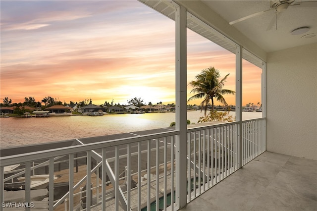 balcony featuring a water view and a ceiling fan