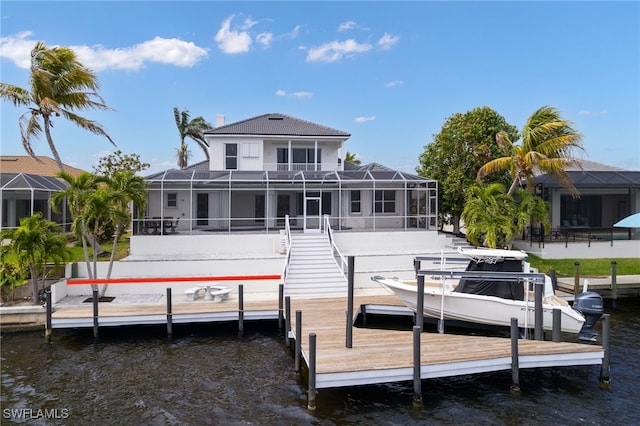 back of house featuring a water view, boat lift, and a lanai