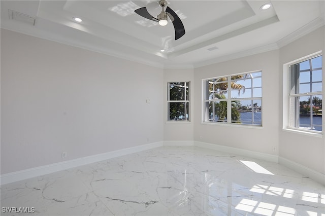 unfurnished room featuring a raised ceiling, marble finish floor, recessed lighting, crown molding, and baseboards