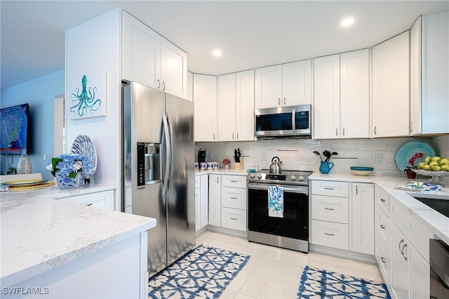 kitchen with stainless steel appliances, white cabinetry, and tasteful backsplash