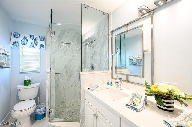 full bathroom featuring toilet, a marble finish shower, baseboards, and vanity