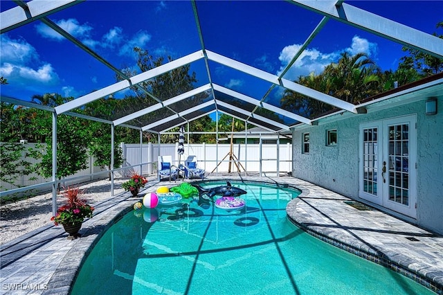 view of swimming pool featuring a fenced in pool, french doors, a patio, glass enclosure, and a fenced backyard