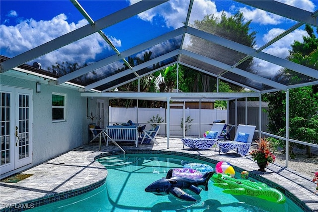 outdoor pool with a patio, french doors, fence, and a lanai