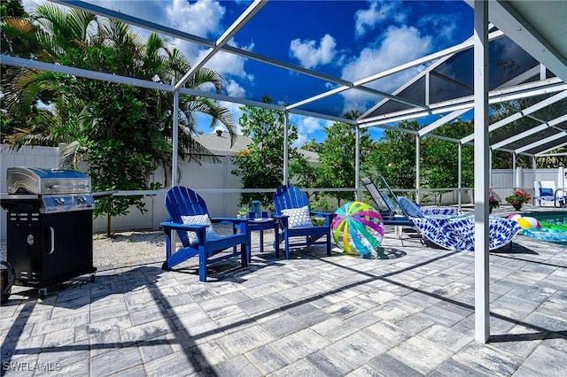 view of patio with glass enclosure, a fenced backyard, and grilling area