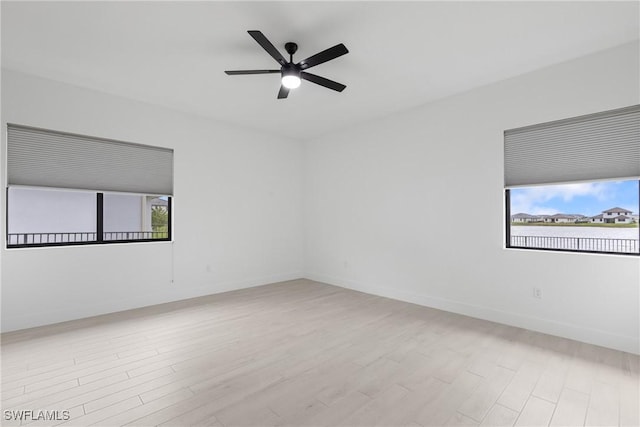 empty room featuring a ceiling fan, baseboards, and wood finished floors