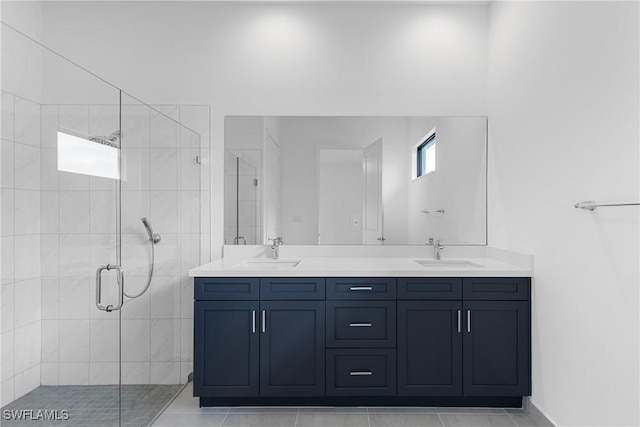 full bathroom featuring double vanity, a shower stall, and a sink