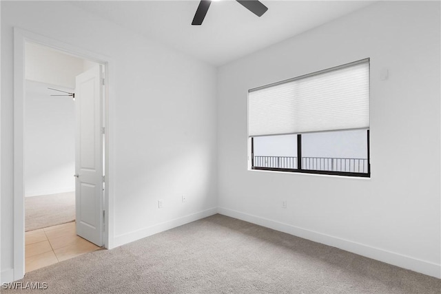 tiled spare room with a ceiling fan, baseboards, and carpet flooring