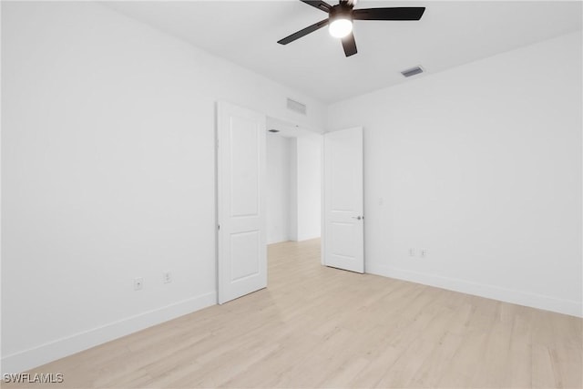 unfurnished room with light wood-type flooring, baseboards, and visible vents