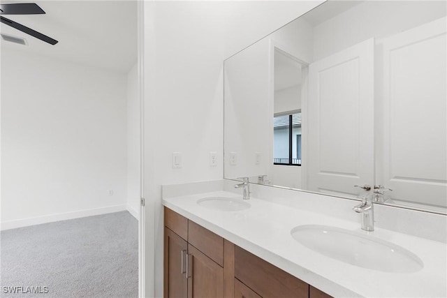 bathroom featuring double vanity, a sink, a ceiling fan, and baseboards