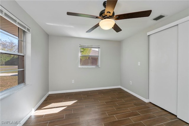 unfurnished bedroom with wood finish floors, a closet, visible vents, and baseboards